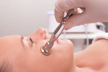 The cosmetologist makes the procedure Microdermabrasion of the facial skin