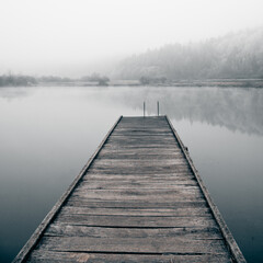 Fototapeta premium Wooden pier on a frosty lake. Way to hardening.