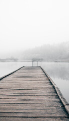 Wooden pier on a frosty lake. Way to hardening.