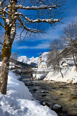 Fototapeta na wymiar Winter landscape with church and Alps mountains in the snow
