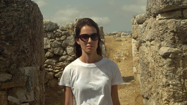 Young woman traveler walk and explore of the ancient city ruins of antique Xanthos town.