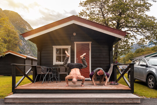 Two People Doing Morning Exercises On The Porch In Norwegian Camping Site