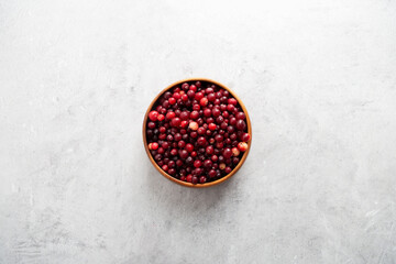 Top view cranberry in wooden bowl at gray background