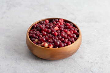Obraz na płótnie Canvas Cranberry at wooden bowl at gray background