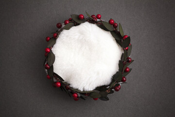 Christmas wreath with red berries and white fur on a dark background 