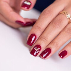 Beautiful female hands with luxury manicure nails, wine red gel polish, on white background