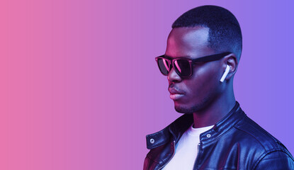 Banner of handsome african american man wearing wireless earphones and leather jacket