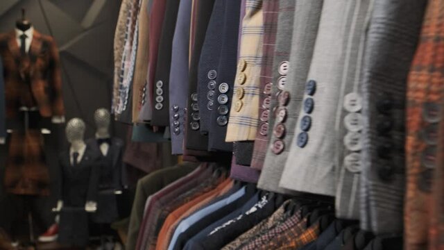 Shop jacket men series, business hanger clothing. Colorful male suits in row in a hanger 4k