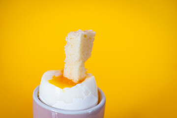 Huevo pasado por agua sobre fondo amarillo