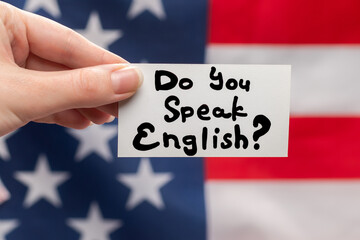 Do you speak English text on a card. American flag background.