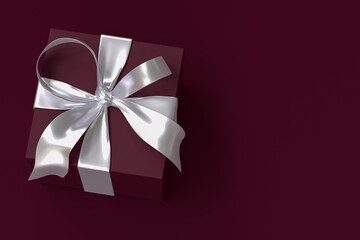 Crimson gift box 3d with silver ribbon and bow on Crimson background