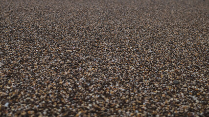 Background of coarse-grained brown beach sand. Selective focus.