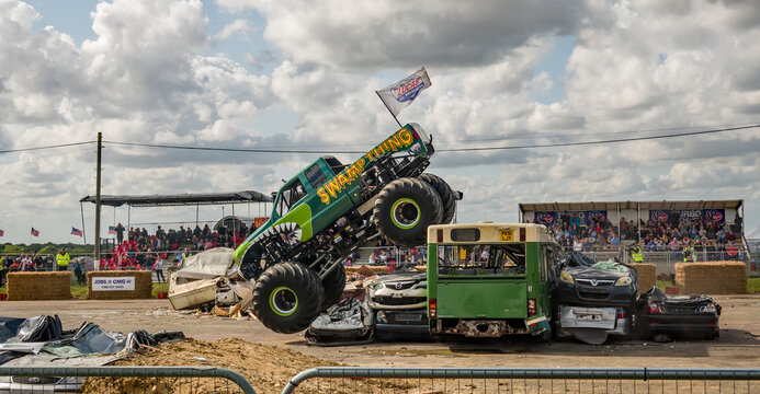 Podington, Bedfordshire, UK &ndash; August 18 2019. An illustrative photo of  the monster truck Swamp Thing jumping over some cars during a public demonstration