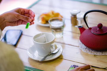 Manos de una persona preparandose un té