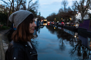 Portrait of an attractive young female with little Venice canal in the background at dusk