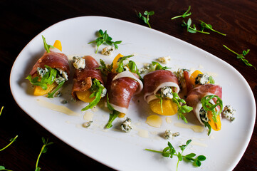 Beef carpaccio on black plate with mustard and parmesan