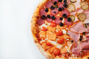 Italian pizza four seasons with ham, cucumber, olives and salmon close-up.  Italian fast food delivery.