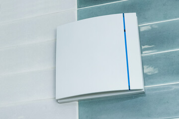 electric ventilation in the bathroom. close-up of white ventilation on a tiled wall