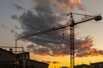 Silhouette of a crane at a construction site at sunset