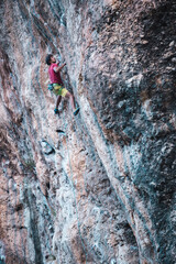 Climber overcomes a difficult climbing route on a natural terrain.