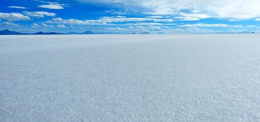 Salt flats of Uyuni,  Bolivia, Altiplano plateau. White vast. Endless Atacama desert. Blue sky. Spectacular landscape Salar de Tunupa. Amazing infinity wilderness Salar de Uyuni.