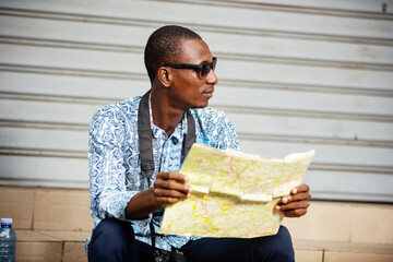 young tourist adventurer holding a map of the city