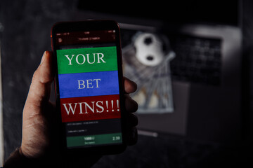 Lucky winner at football betting with phone in hand. Betting and sport concept.