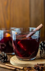 traditional winter hot alcohol drink in transparent glass close up, christmas homemade mulled wine or grog or punch on dark wooden table