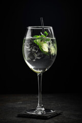 Hugo cocktail with Prosecco, lime, ice, mint and Melissa syrup on a stone background, aperitif drink