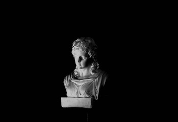 Reproduction of ancient sculpture. beautiful lighting black and white bust photo of a woman

