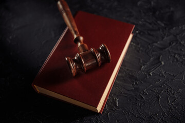 Judge gavel with red book on a table.