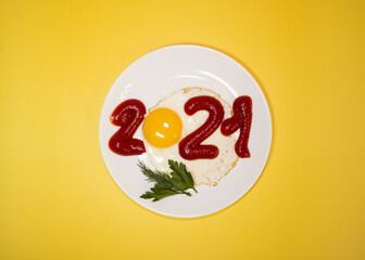 Fries Eggs with ketchup and herbs. Inscription 2021. Holiday breakfast