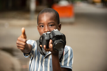 beautiful little boy holding a camera