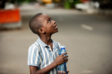 little boy holding a plastic water bottle
