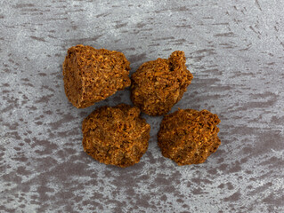 Overhead view of four gluten free chocolate macaroons on a gray background.