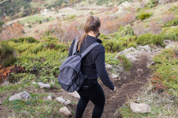 Naklejka na ściany i meble Young female hiker walking on the mountain during covid-19