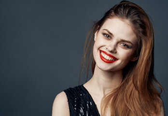 Model lady with red hair on gray background and black dress