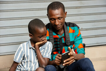 young father and his son using a mobile phone
