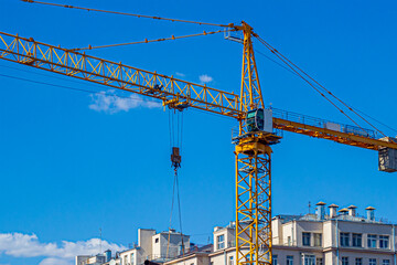 Fototapeta na wymiar Yellow construction crane, on a construction site