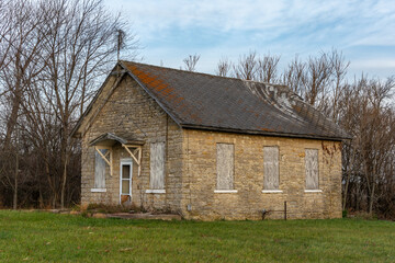 Fototapeta na wymiar Old abandoned stone one room schoolhouse in the morning light. Trivoli, Illinois.
