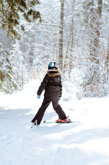 Fototapeta na wymiar child having sport activity of skiing in winter woodland