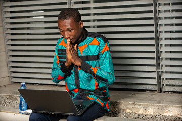 handsome young man using a laptop - obrazy, fototapety, plakaty