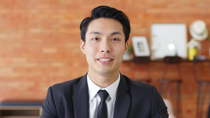 POV Young Asian businessman talking on video call or virtual meeting in office, front view, look at camera