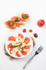 Caprese and Toast bruschetta with mozzarella cheese, cherry tomatoes and fresh garden basil. Traditional Italian food, healthy natural breakfast, cholesterol and GMO free, space for text,