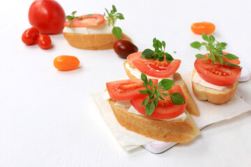 Caprese and Toast bruschetta with mozzarella cheese, cherry tomatoes and fresh garden basil. Traditional Italian food, healthy natural breakfast, cholesterol and GMO free, space for text,