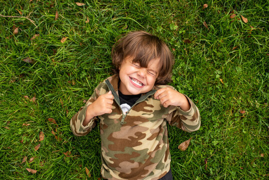 Little boy laughing on green grass