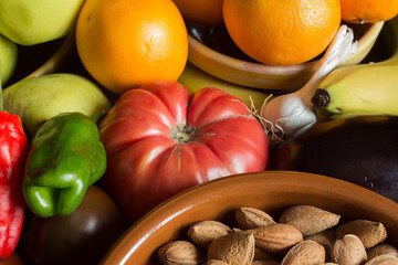 Close-up of vegetables, nuts, fruits, and other natural ingredients on wooden board. Vegan and healthy food.
