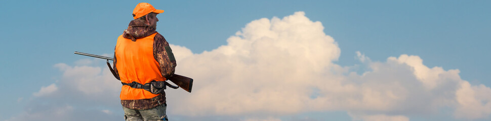 Silhouette of a hunter with a gun against the sun, an ambush for ducks.