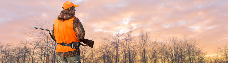 Silhouette of a hunter with a gun against the sun, an ambush for ducks.