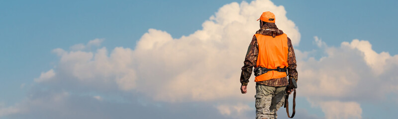 Silhouette of a hunter with a gun against the sun, an ambush for ducks.